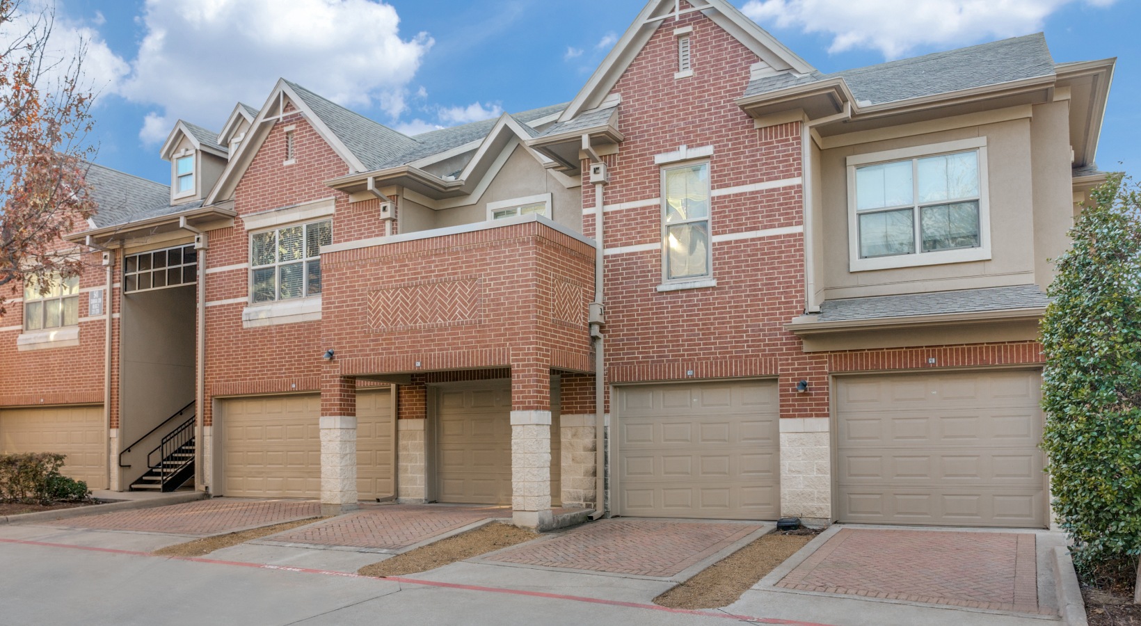a two story townhouse with garages and a driveway at The  Franklin at Samuels Ave