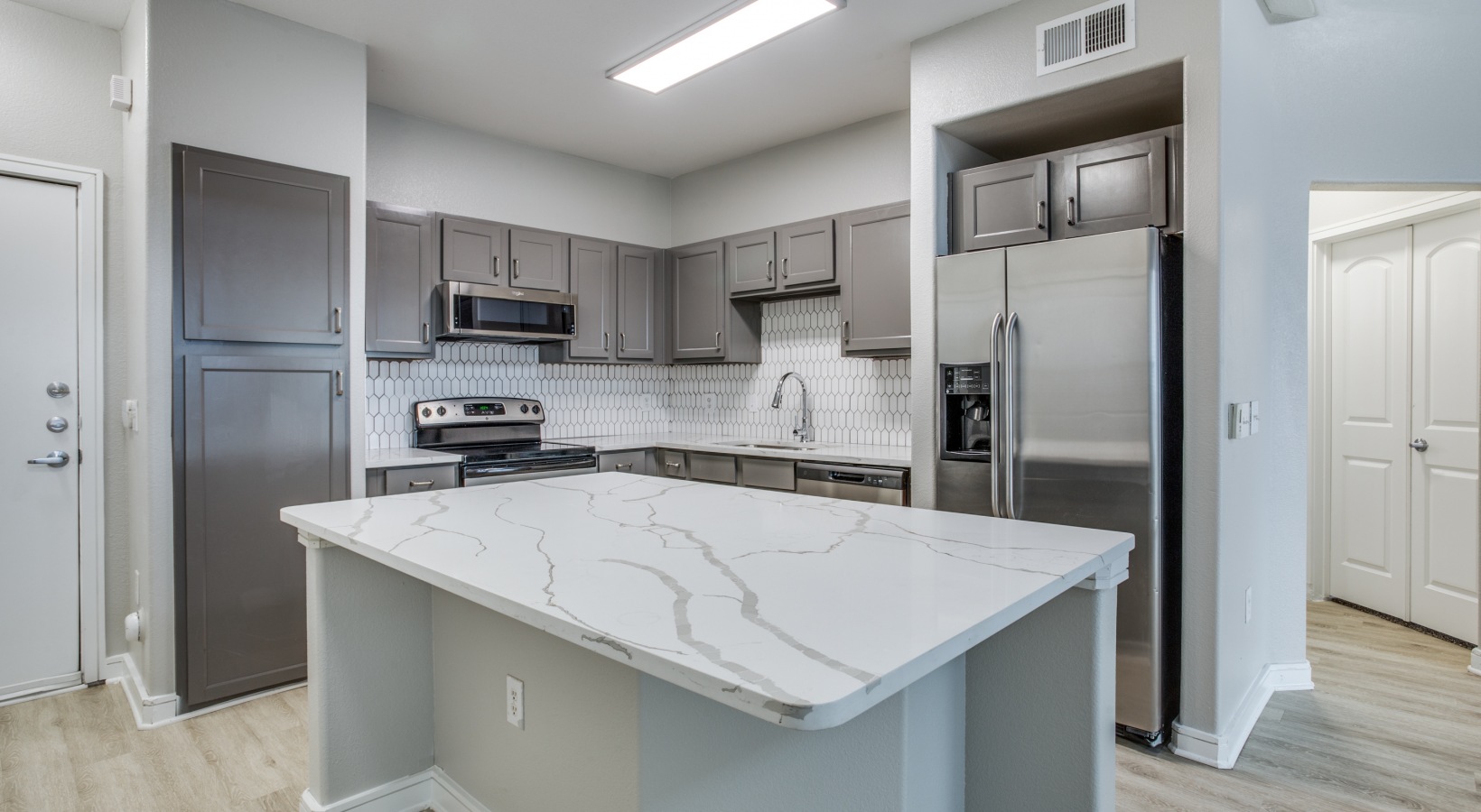 a kitchen with stainless steel appliances and granite counter tops at The  Franklin at Samuels Ave