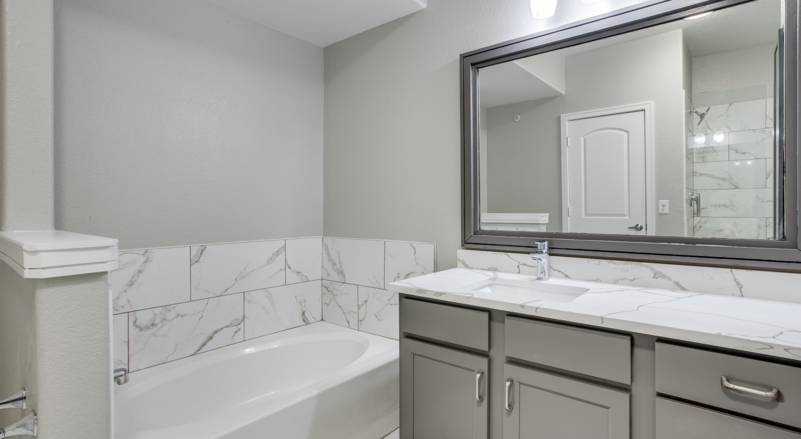 a bathroom with a white vanity and marble counter tops at The  Franklin at Samuels Ave