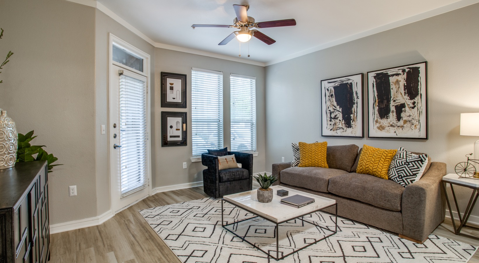 a living room with a ceiling fan and a rug at The  Franklin at Samuels Ave