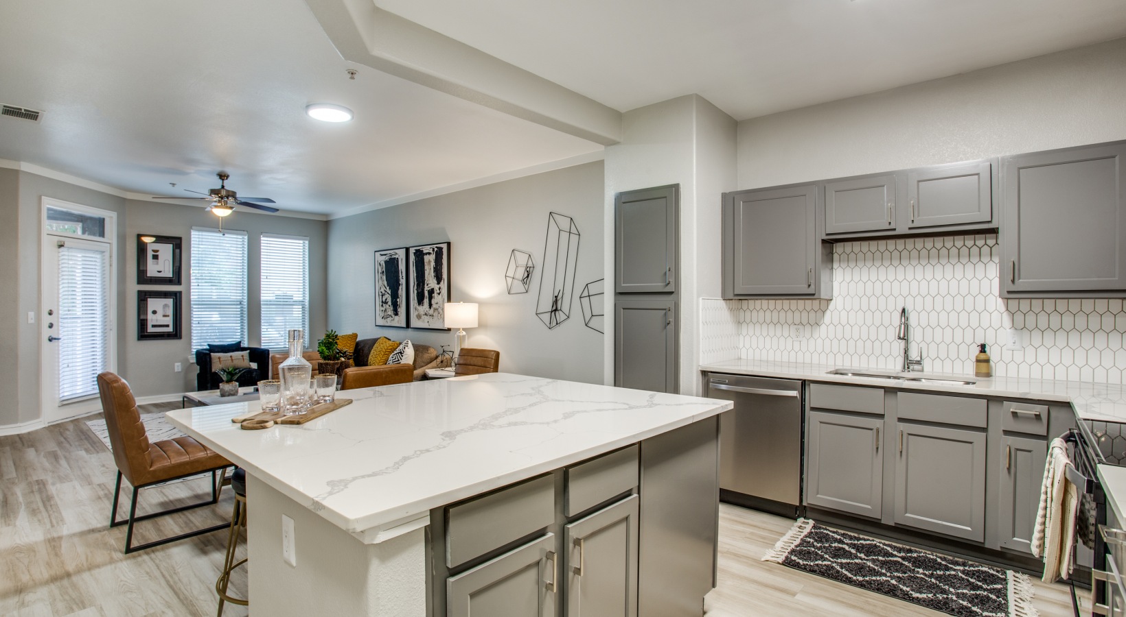 a kitchen with gray cabinets and stainless steel appliances at The  Franklin at Samuels Ave