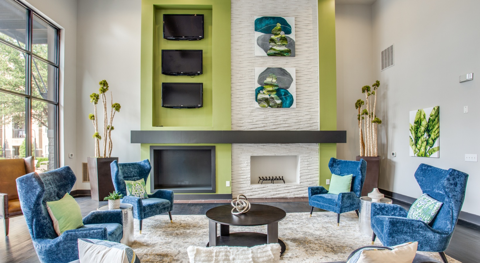 a living room with blue and green accents and a fireplace at The  Franklin at Samuels Ave