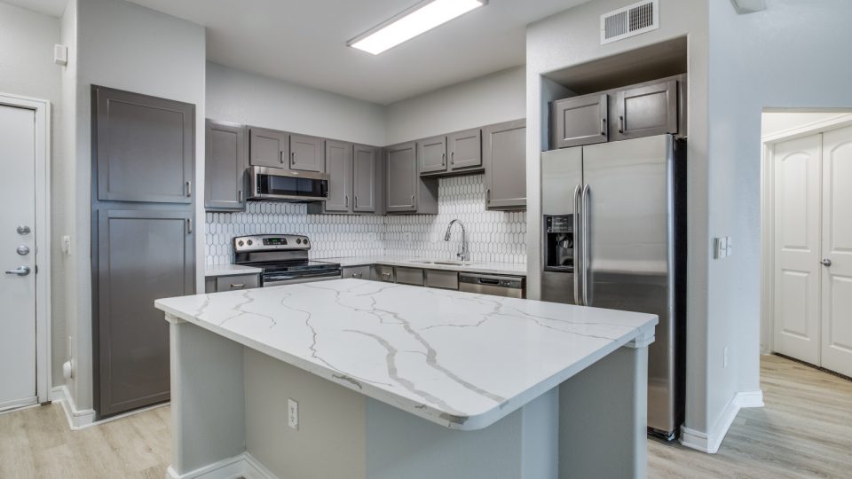 a kitchen with stainless steel appliances and granite counter tops at The  Franklin at Samuels Ave
