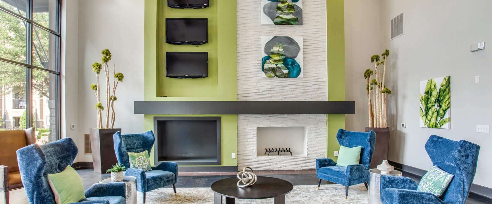 a living room with blue and green accents and a fireplace at The  Franklin at Samuels Ave